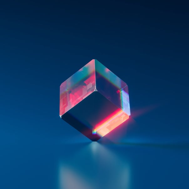 A clear crystal cube reflecting red light